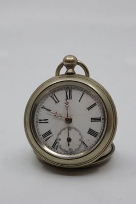 a small gold pocket watch with roman numerals on it