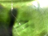a green vase sitting on a table next to a glass vase
