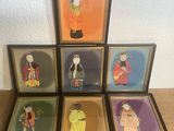 six framed asian figurines are displayed on a wooden table