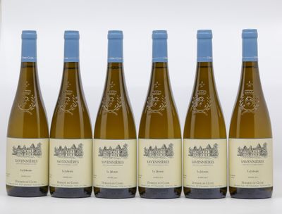 six bouteilles de vin blanc sont alignées