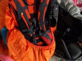 an orange and black backpack sitting on top of a bed