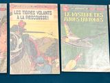 four books are lined up on a blue surface