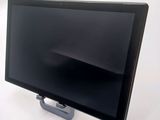 a black computer monitor on a stand on a white table