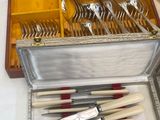 silverware in a silver case on a table with a red cloth