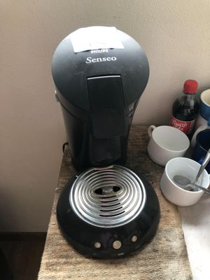 a coffee maker sitting on a counter next to a cup of coffee