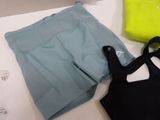 a bag, a pair of shorts, and a tote bag sitting on a table
