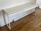 un bureau blanc dans un coin de la pièce