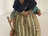 a doll of an old woman with a hat and scarf