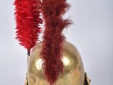 a gold helmet with a red feather on top of it
