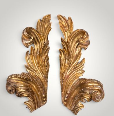a pair of gilded gold leaf brackets on a white background