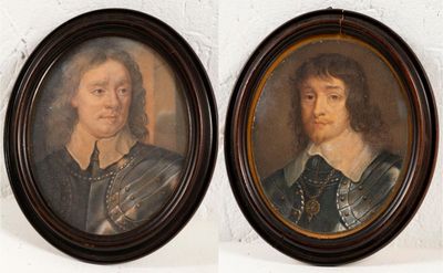 Deux portraits, celui d'un homme et celui d'une femme, sont accrochés au mur.