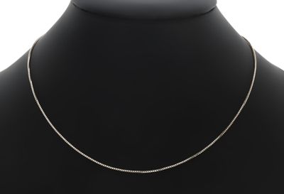 un collier en argent autour du cou d'un mannequin, sur fond blanc