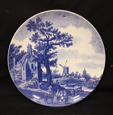 a blue and white plate with a picture of a farm scene