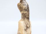 a statue of a bird sitting on top of a marble block