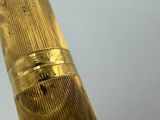 a close up of a gold pen with a white background