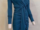 Le mannequin porte une robe bleue nouée à la taille.