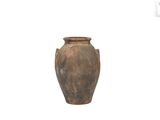 un vase brun posé sur une surface blanche
