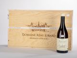 une bouteille de vin posée sur une table à côté d'une caisse en bois