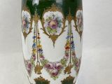 un vase vert avec des fleurs posé sur une table