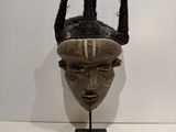 an image of a wooden mask with horns on a stand
