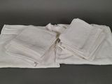 Plusieurs serviettes blanches sont empilées les unes sur les autres sur une table