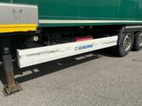 un grand camion vert avec une bande jaune sur le côté
