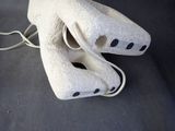 a white mask with black dots on it sitting on a table