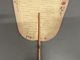 a small fan with a wooden handle on the wall