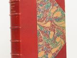 un vieux livre à la couverture rouge ornée d'un motif floral