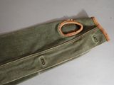 a green bag with a wooden handle on a table
