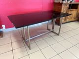 a glass table with a metal base in a room
