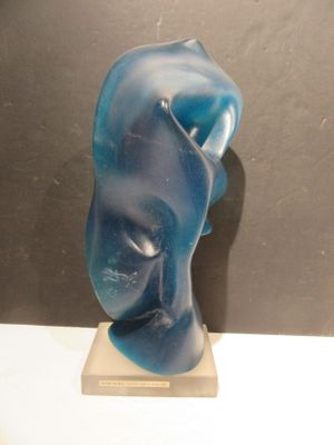 une sculpture bleue représentant le visage d'une femme, posée sur un socle