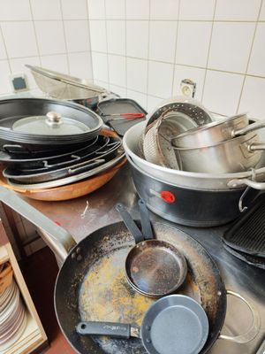 several pots and pans are on a stove top in a kitchen