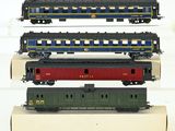 trois trains miniatures sont empilés les uns sur les autres sur une surface blanche