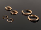 a group of gold rings on a black surface