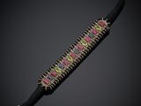 un gros plan sur un bracelet noir orné de pierres roses et vertes