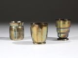 trois vases en argent posés sur une surface blanche