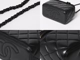 a close up of a black chanel bag with a chain around it