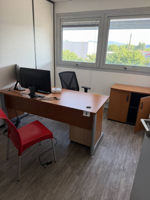 a desk with a computer and a chair in a room