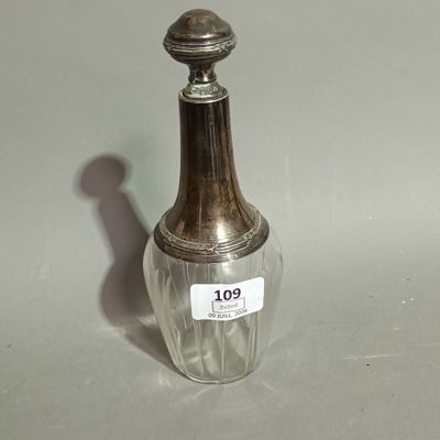 a small glass bottle with a silver lid on a table