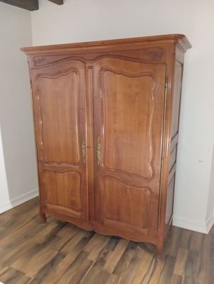 a wooden cabinet in the corner of a room