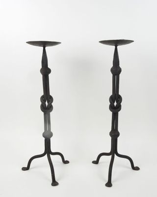 a pair of black iron candlesticks with a circular design