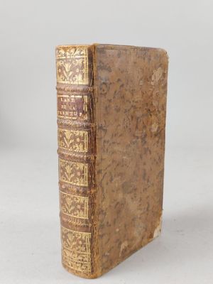 an old book sitting on top of a table next to a white wall