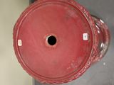 a red vase with a hole in the middle of it