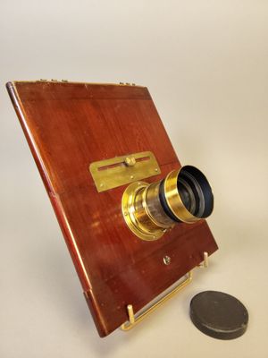 une petite pièce posée à côté d'un petit appareil photo en bois
