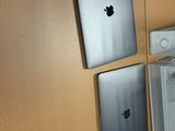 un bureau sur lequel se trouvent un ordinateur portable, un écran et d'autres appareils électroniques