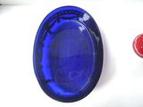 a blue glass plate with a red candle on it