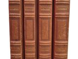 trois vieux livres sont alignés sur un fond blanc