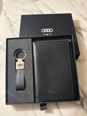 a black leather wallet and keychain in a black box
