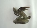 a statue of a bird sitting on top of a green object